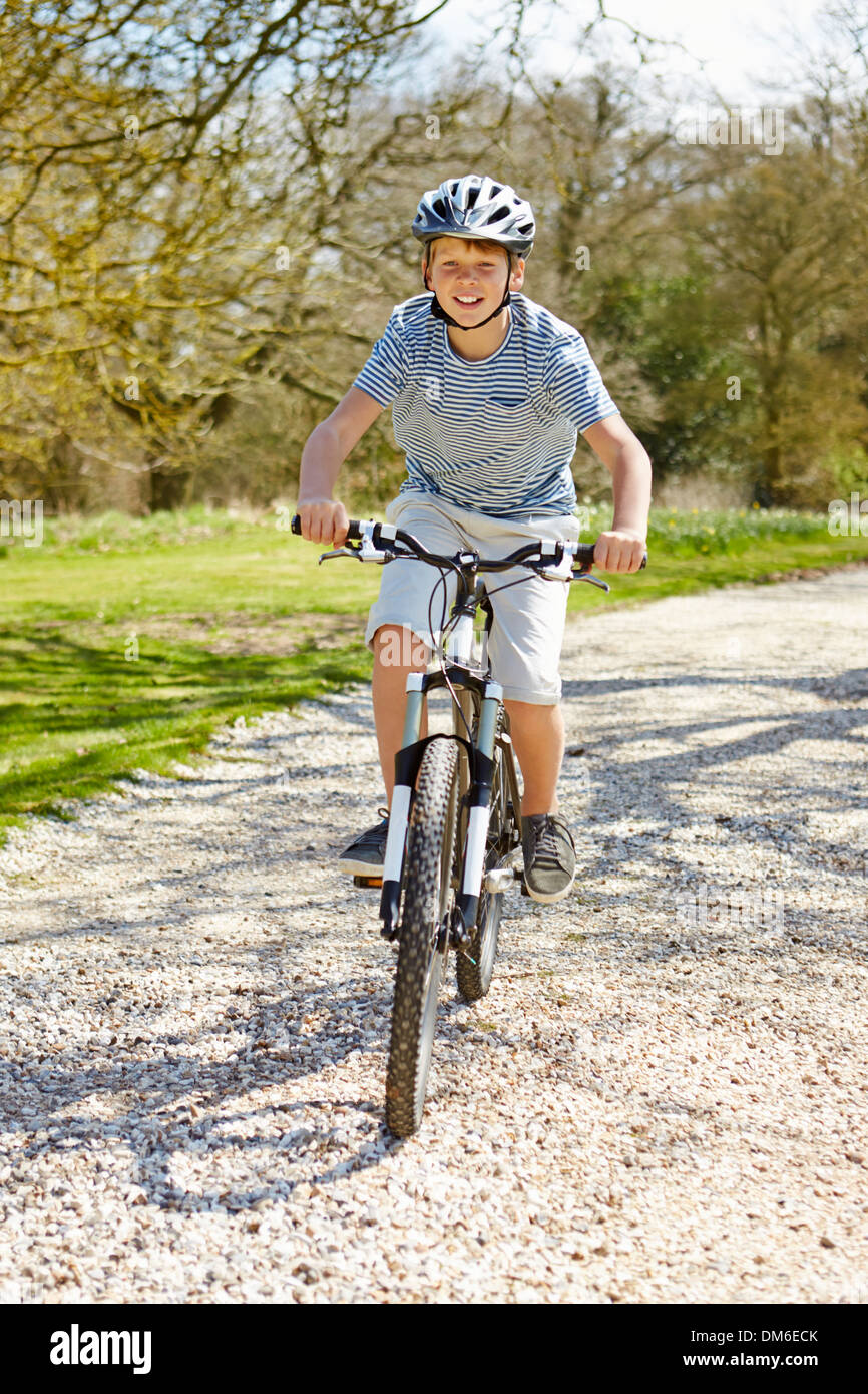 Young Boy Riding Bike Along Country Track Stock Photo
