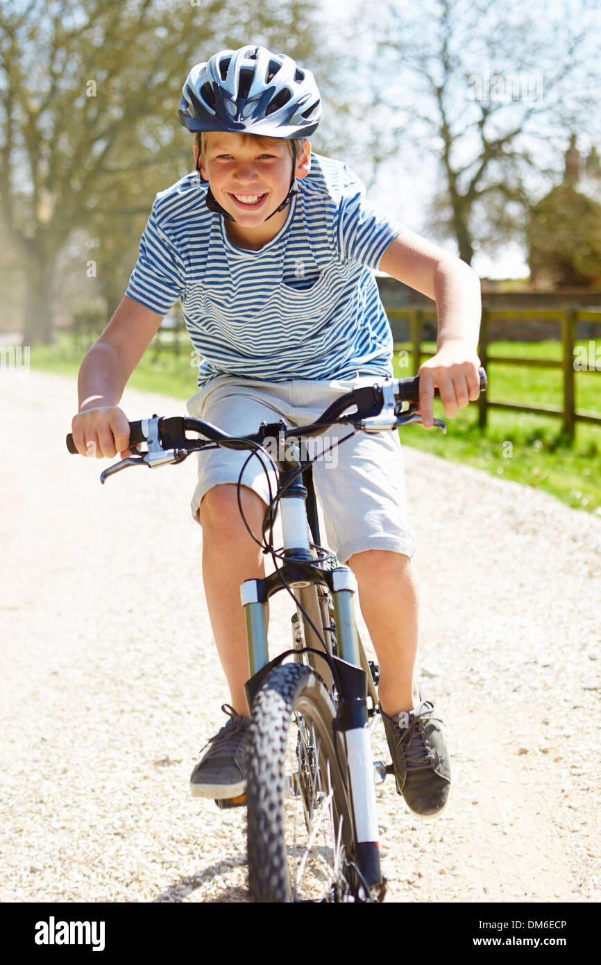 Young Boy Riding Bike Along Country Track Stock Photo