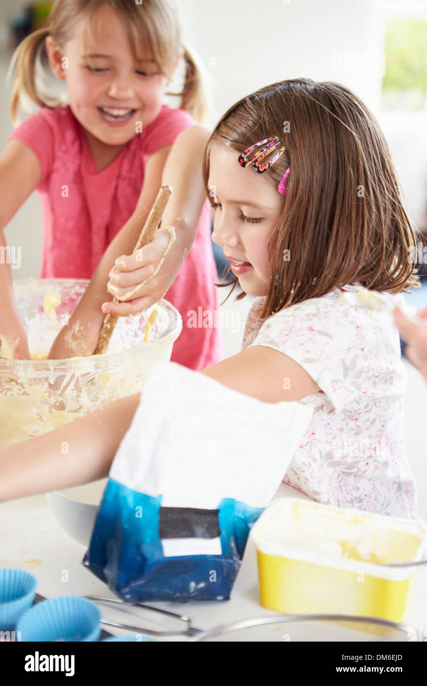 Two Girls Making Cupcakes In Kitchen Stock Photo