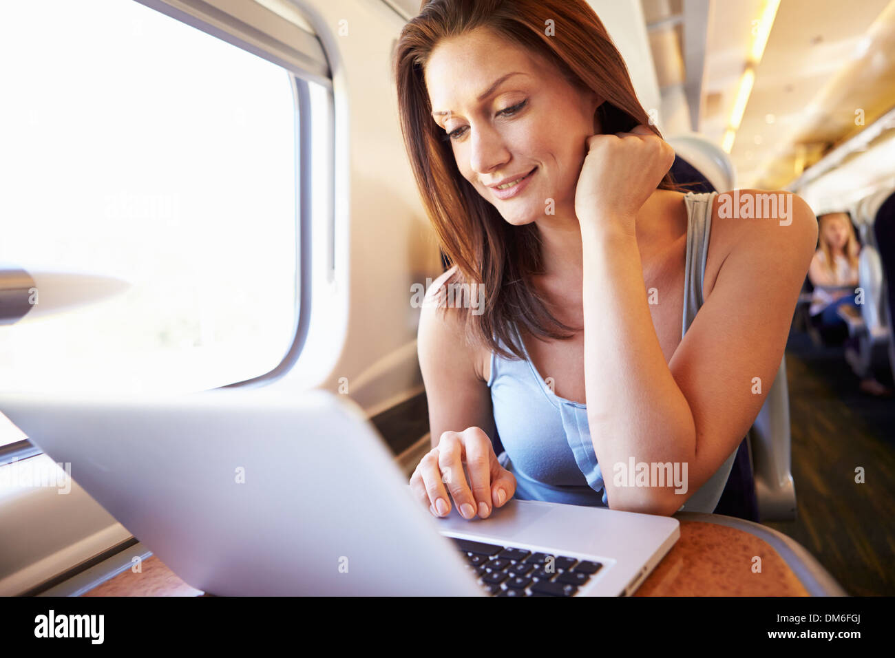 Woman Using Laptop On Train Stock Photo