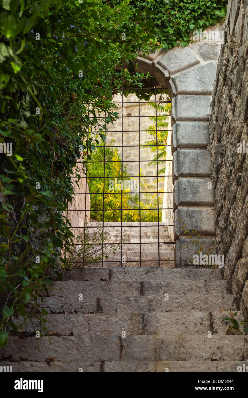 Stone gate locked with rusted steel grating Stock Photo