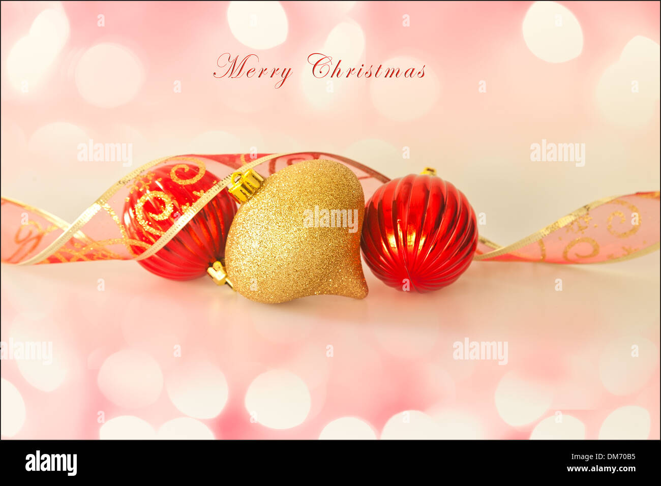 Merry Christmas card, with Christmas decorations, ribbon, soft background lights and text. Room for more text. Stock Photo