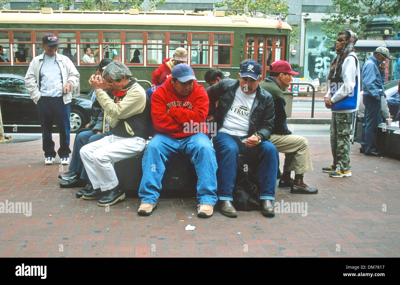 US San Francisco ,Group of men seated hangi out  by trro;;y car halt, Stock Photo