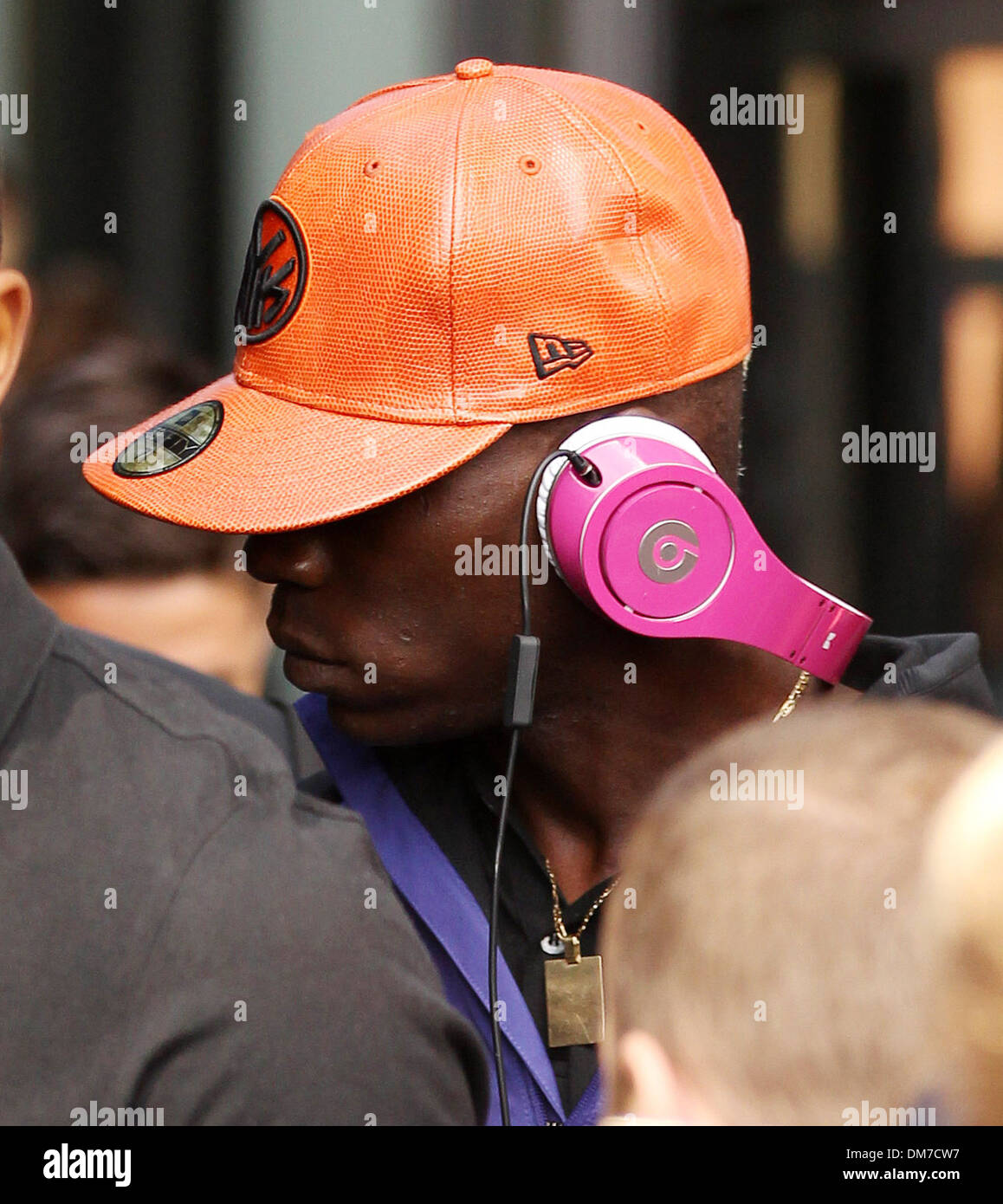 Mario Balotelli leaving a hotel in Liverpool wearing pink Beats By Dre  headphones and a bright orange baseball cap Liverpool Stock Photo - Alamy