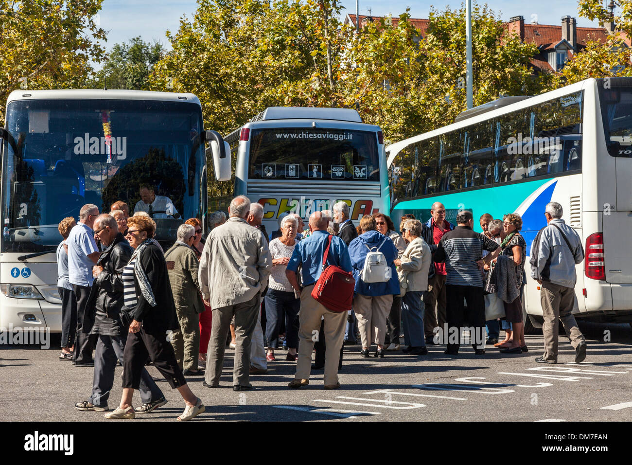 Group of people congregating beside tour coaches, Lake Annecy, Savoie ...