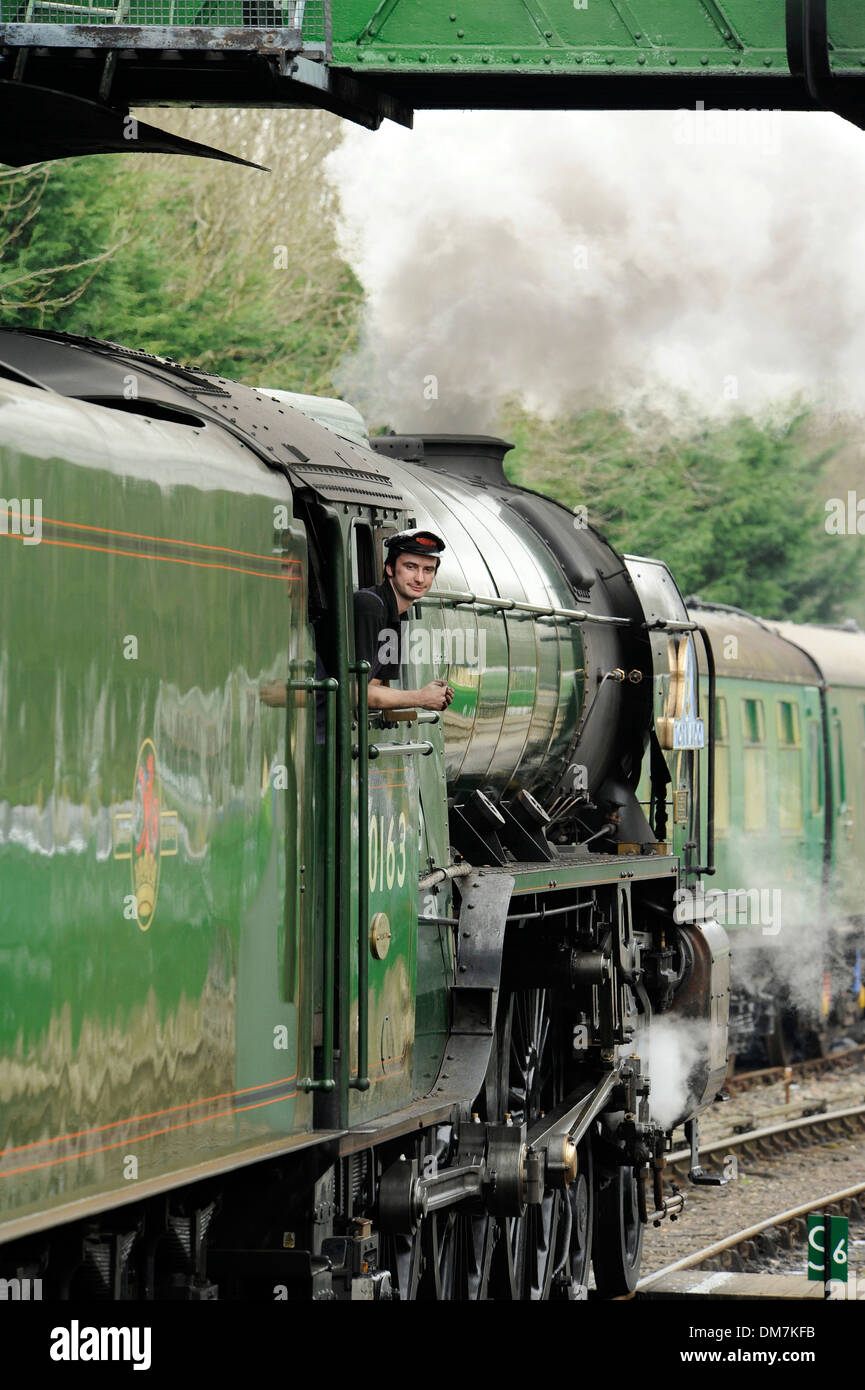 Steam train pulling away from station Stock Photo