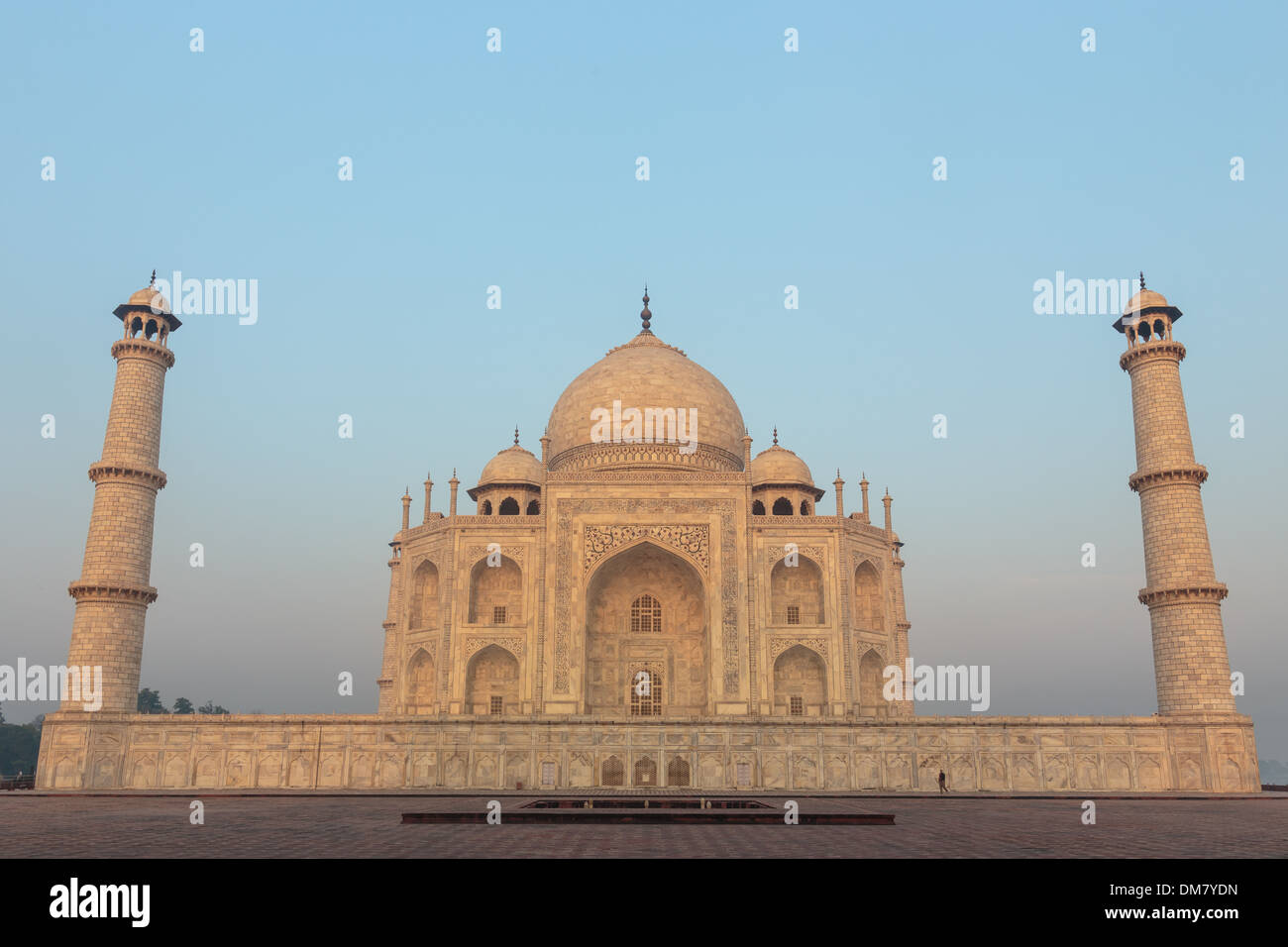 The stunning indo-islamic architecture of the Taj Mahal is complimented by the soft sunrise light over the palace in Agra, India. Stock Photo
