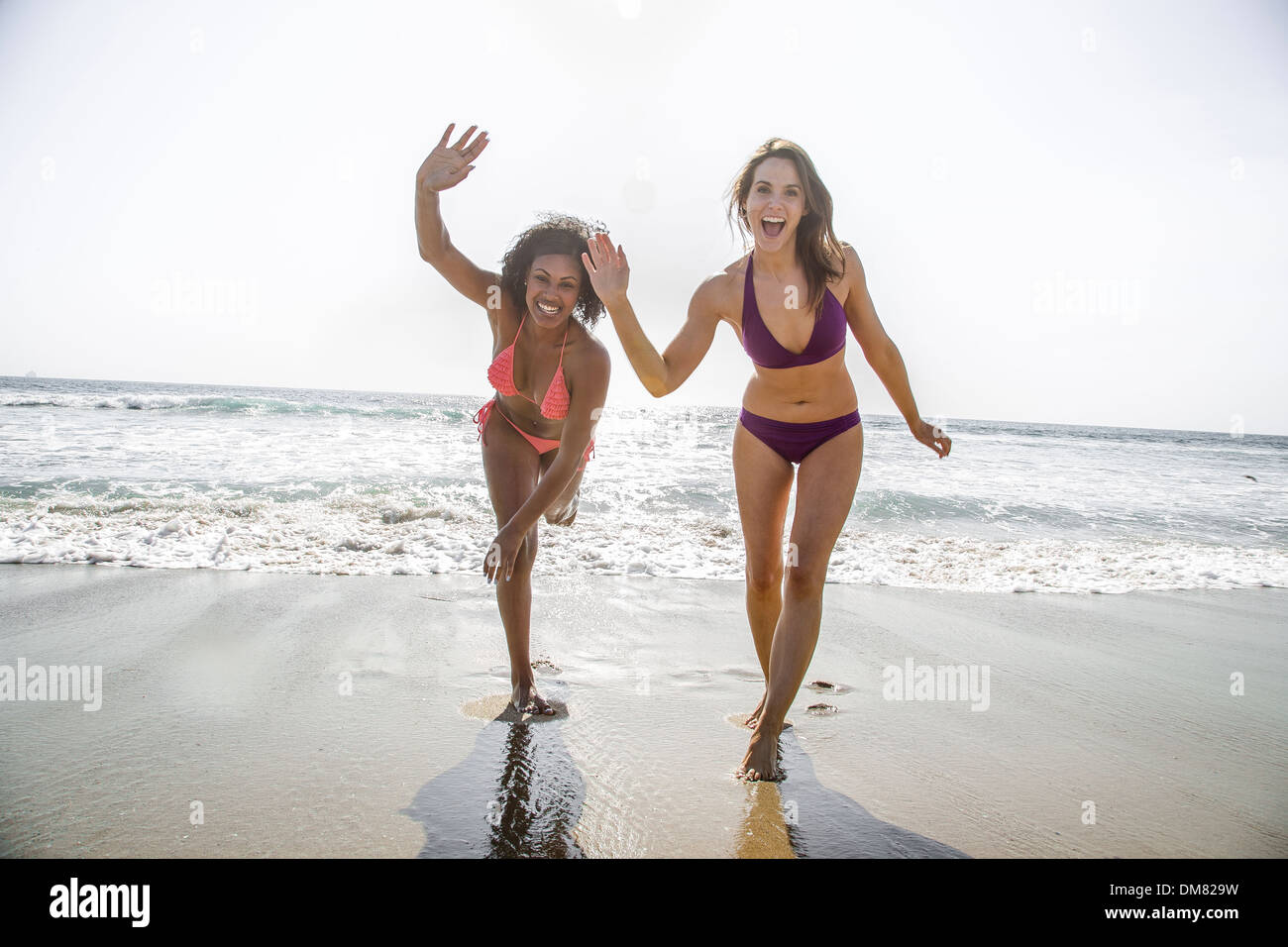Young women in bikinis waving Stock Photo