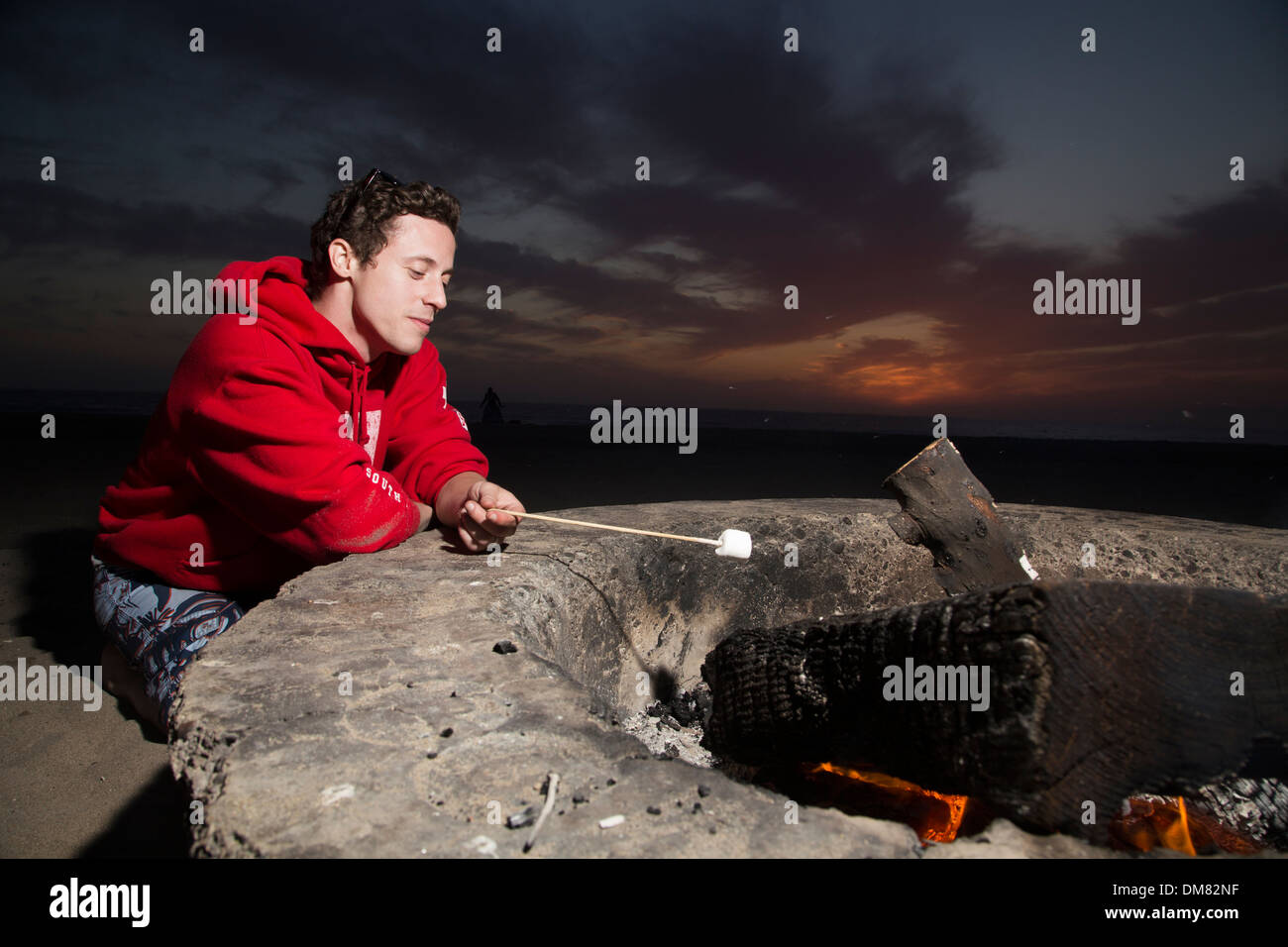 Young man toasting marshmallows in a fire pit Stock Photo Alamy