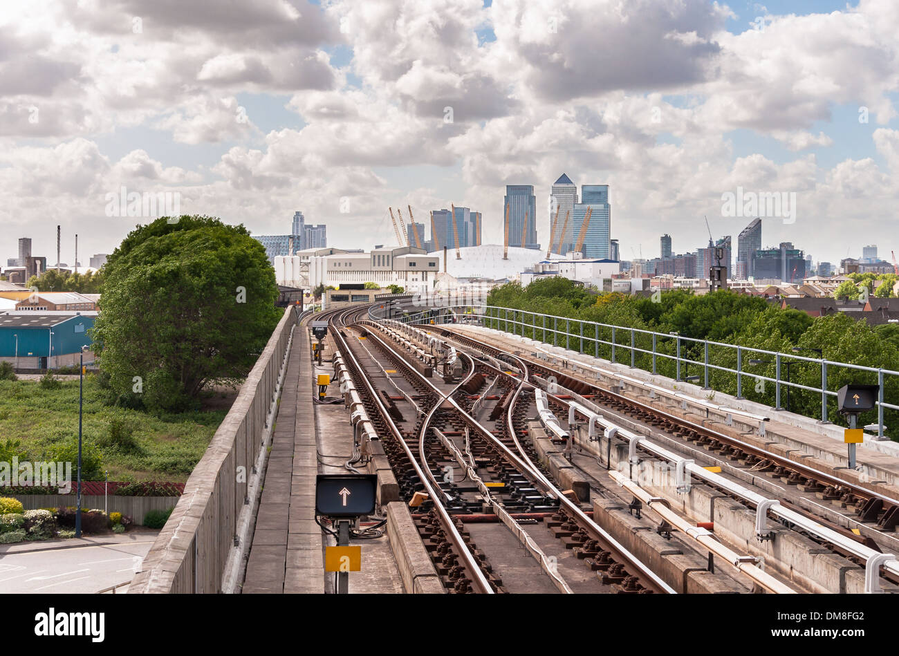 The railway tracks of Docklands Light Railway with Canary Wharf skyscrapers in the background. Stock Photo