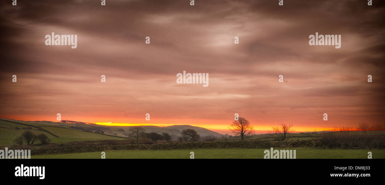 Looking down the valley towards Ulverston, Cumbria as the sun breaks the horizon. Stock Photo