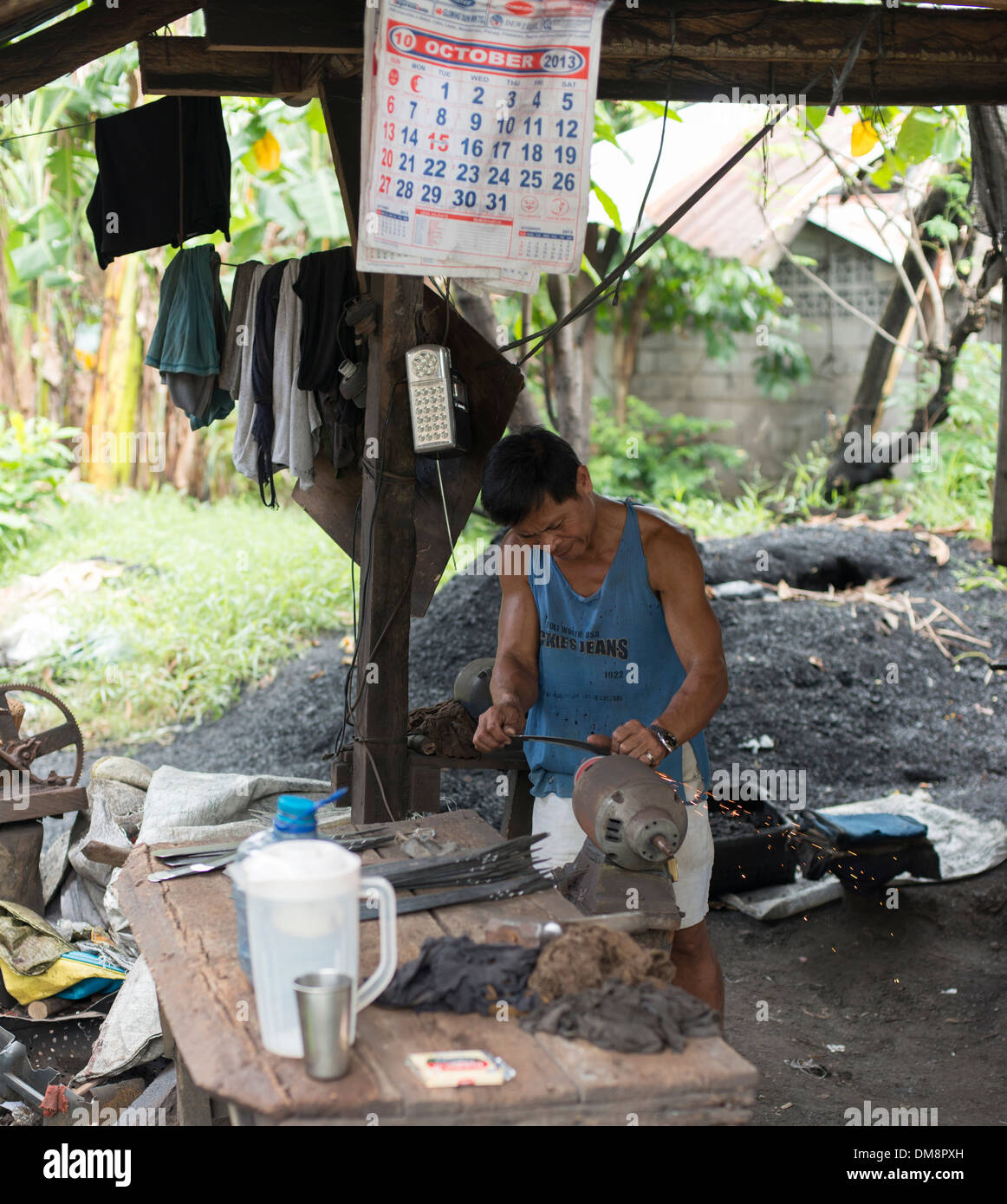 Craftsman sharpening the blade of a machete Stock Photo Alamy