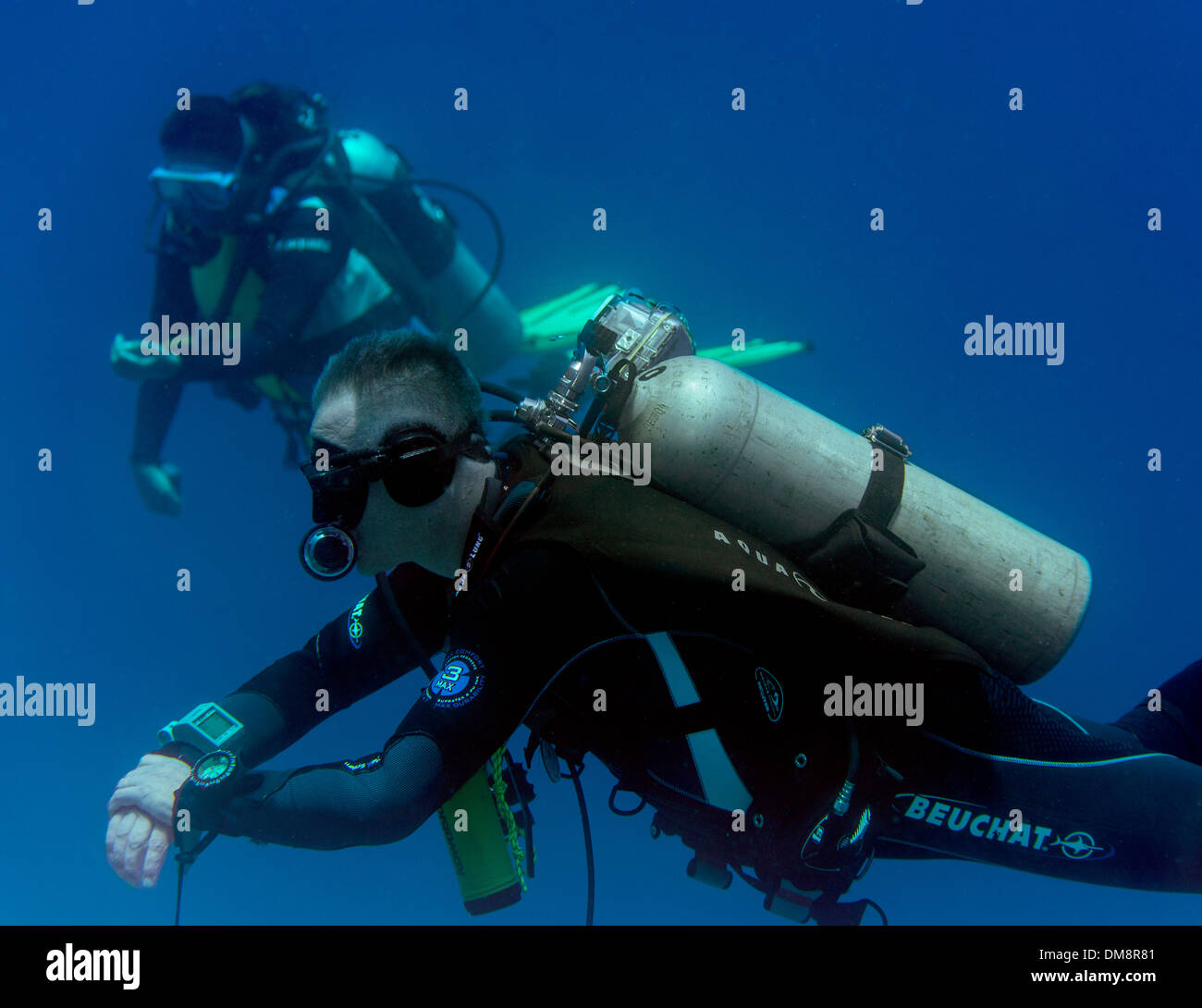 Two divers sitting out their safety stop at the end of a dive Stock