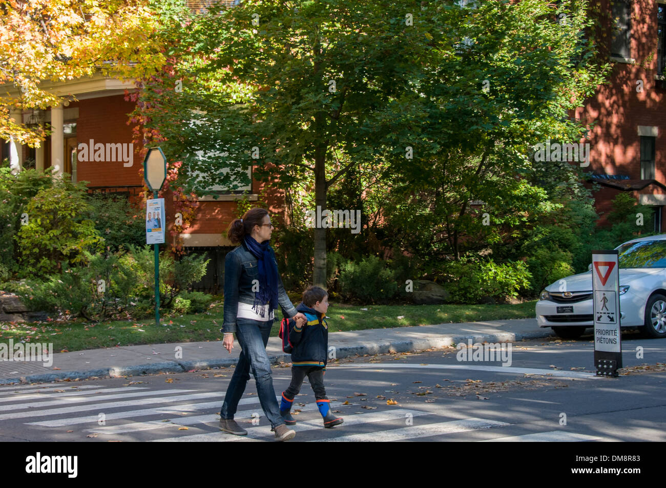 Adult and schoolchild crossing street Montreal Stock Photo