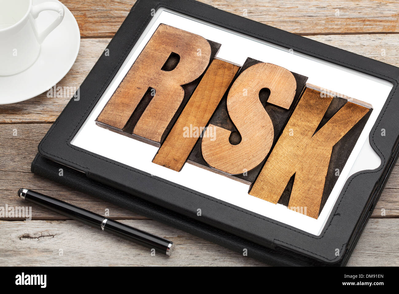 risk - word in letterpress wood type on a digital tablet with a cup of coffee Stock Photo