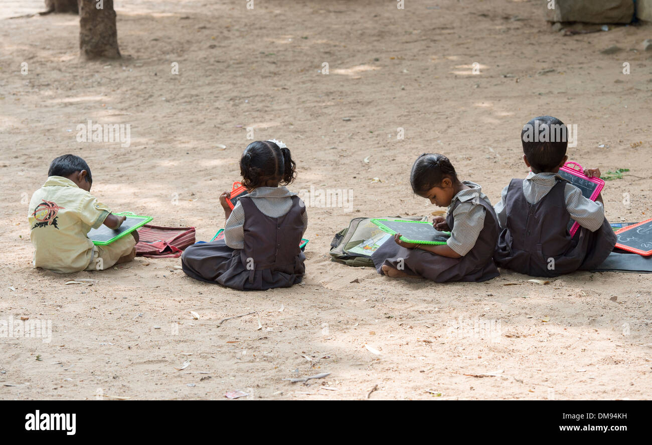 Rural Indian village school children in an outside class writing on a chalk tablets. Andhra Pradesh, India Stock Photo