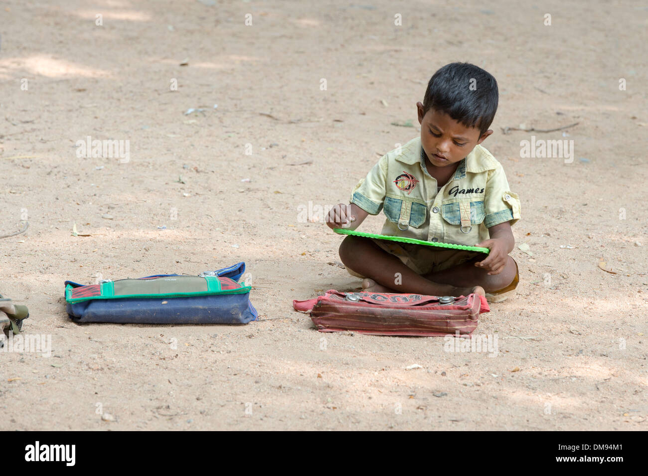 Rural Indian village school boy writing on a chalk tablet in an outside class. Andhra Pradesh, India Stock Photo
