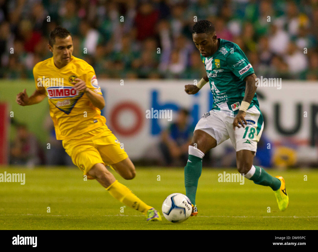 Leon, Mexico. 12th Dec, 2013. Leon's Hernan Burbano (R) vies for the ball with America's Paul Aguilar during the first leg final match of the Liga MX, against America, held in Leon Stadium, in Leon city, Guanajuato, Mexico, on Dec. 12, 2013. © Leopoldo Smith Murillo/Xinhua/Alamy Live News Stock Photo