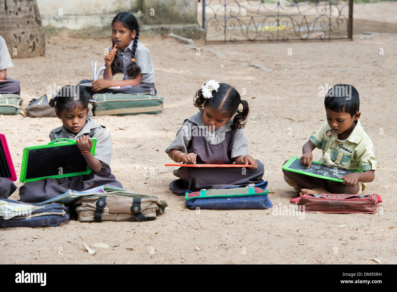 Rural Indian village school children in an outside class writing on a chalk tablets. Andhra Pradesh, India Stock Photo