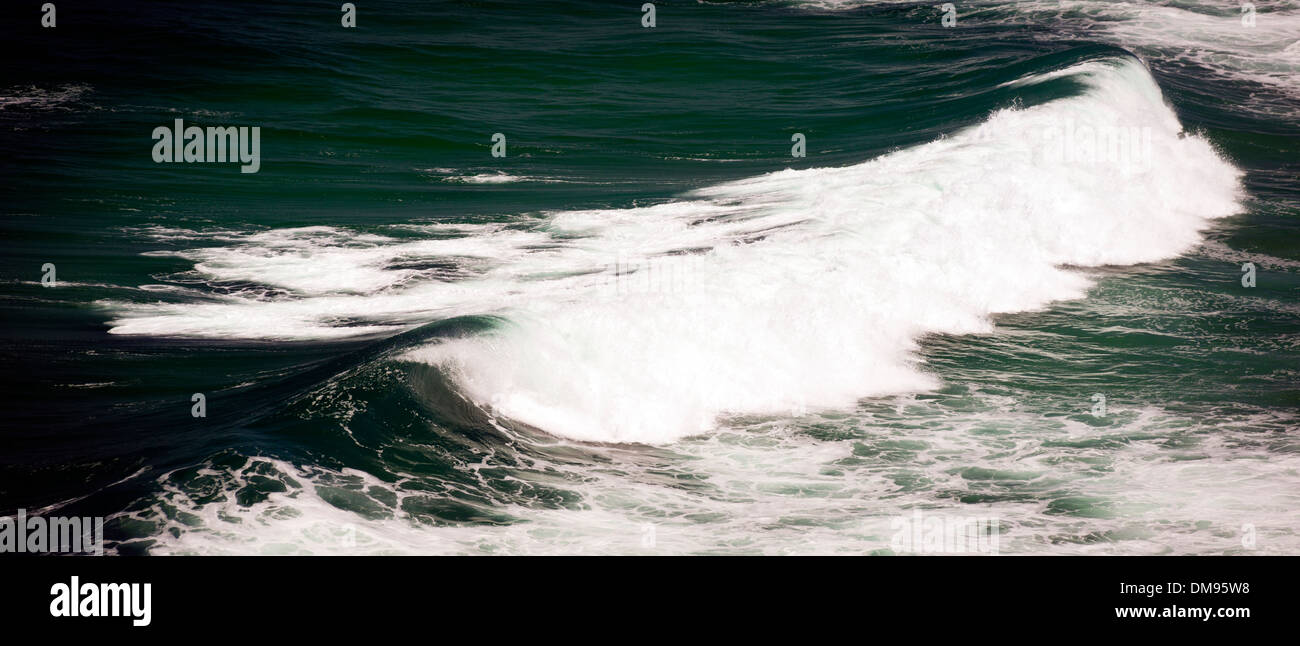 Waves crash and break in the dark ocean Stock Photo