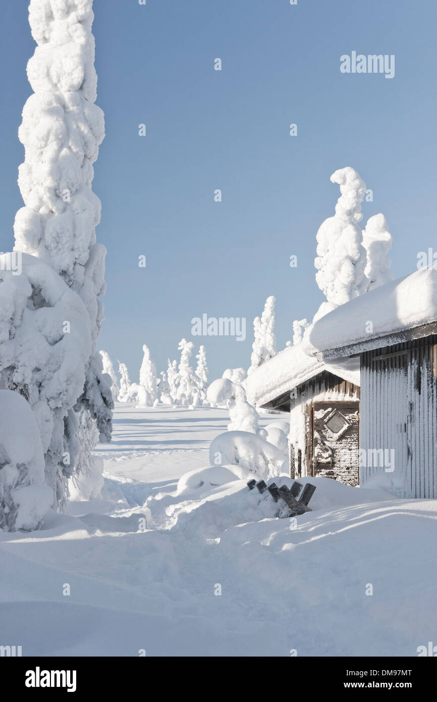 Snowy wood made huts or log cabins in snowy forest in Riisitunturi, Finland Stock Photo