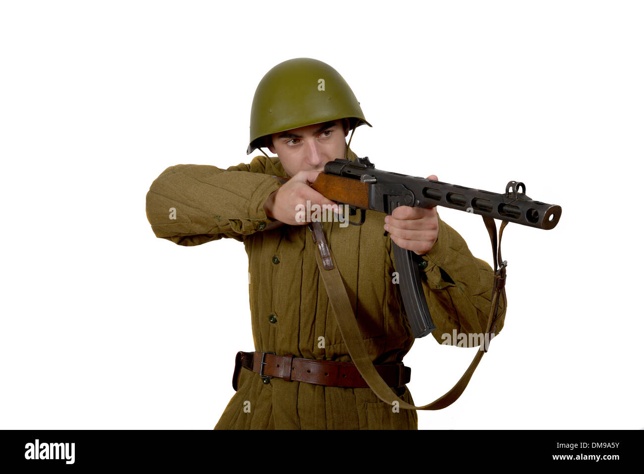 young Soviet soldier shoots with his ppsh 41. He have a helmet Stock Photo