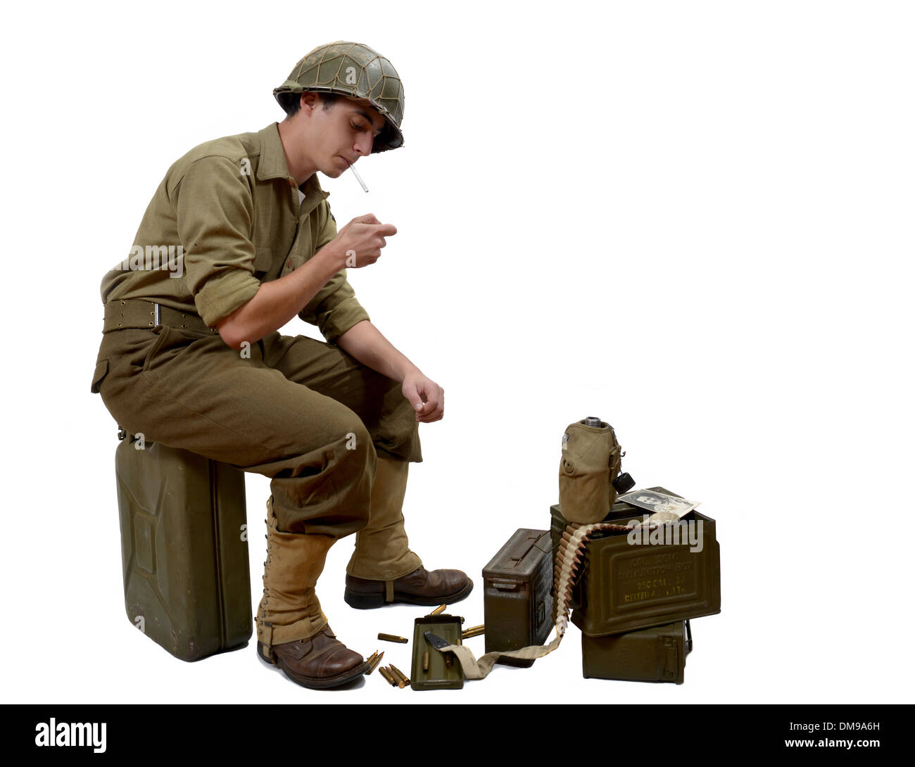 young American soldier sitting on a jerrycan lights a cigarette Stock Photo
