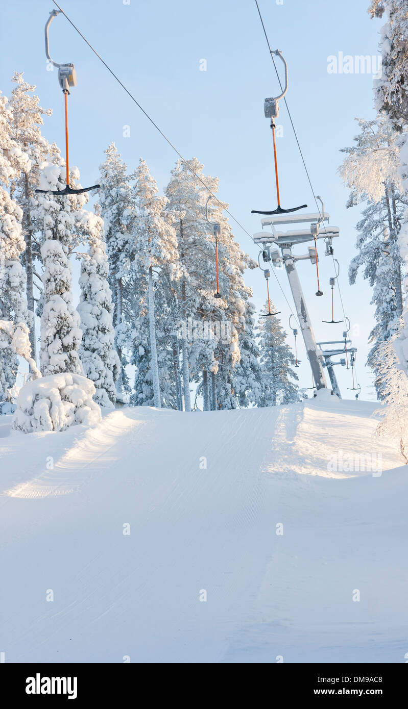 Ski elevators of lifts between snowy forest in ski resort at winter Stock Photo