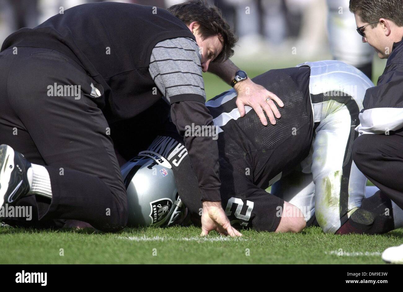 Oakland Raider quarterback Rich Gannon is looked over by team doctors