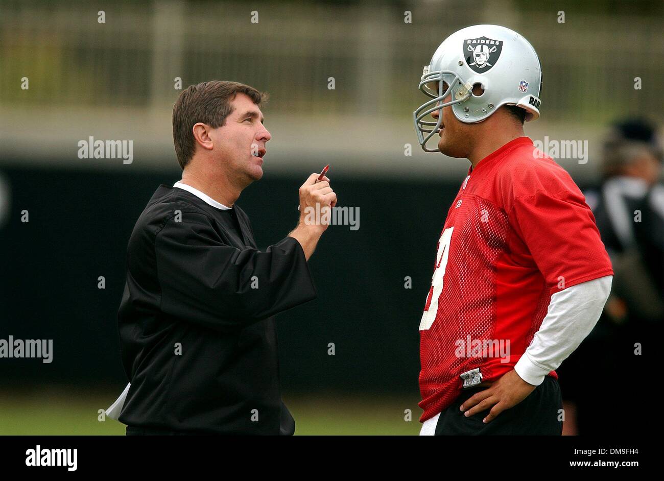 Oakland Raider backup quarterback Marques Tuiasosopo (right - cq) talks with head coach Bill Callahan (cq-left) during a break in the first day of training camp Friday morning at the Oakland Raiders training facility at the Napa Valley Marriott. Sacramento Bee photograph by Jose Luis Villegas July 26, 2002/ZUMA Press Stock Photo