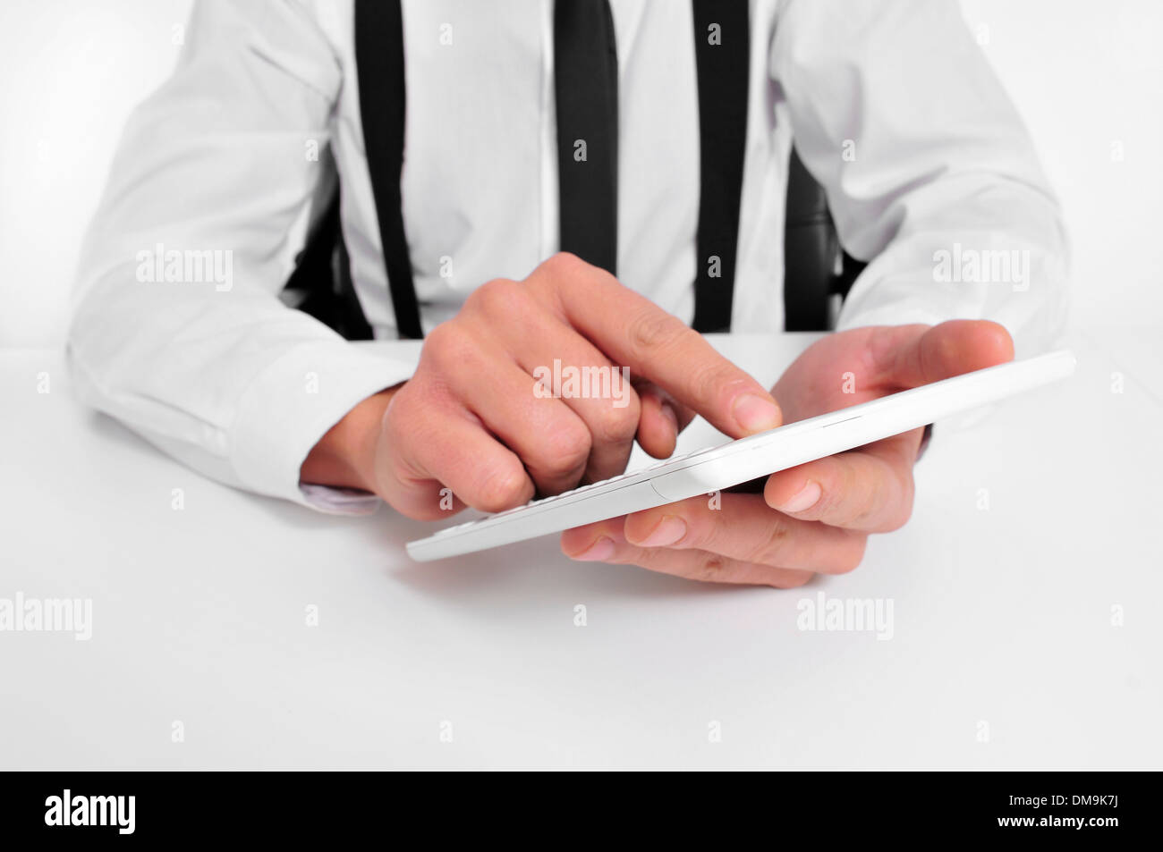 a businessman sitting in a desk using a tablet computer Stock Photo