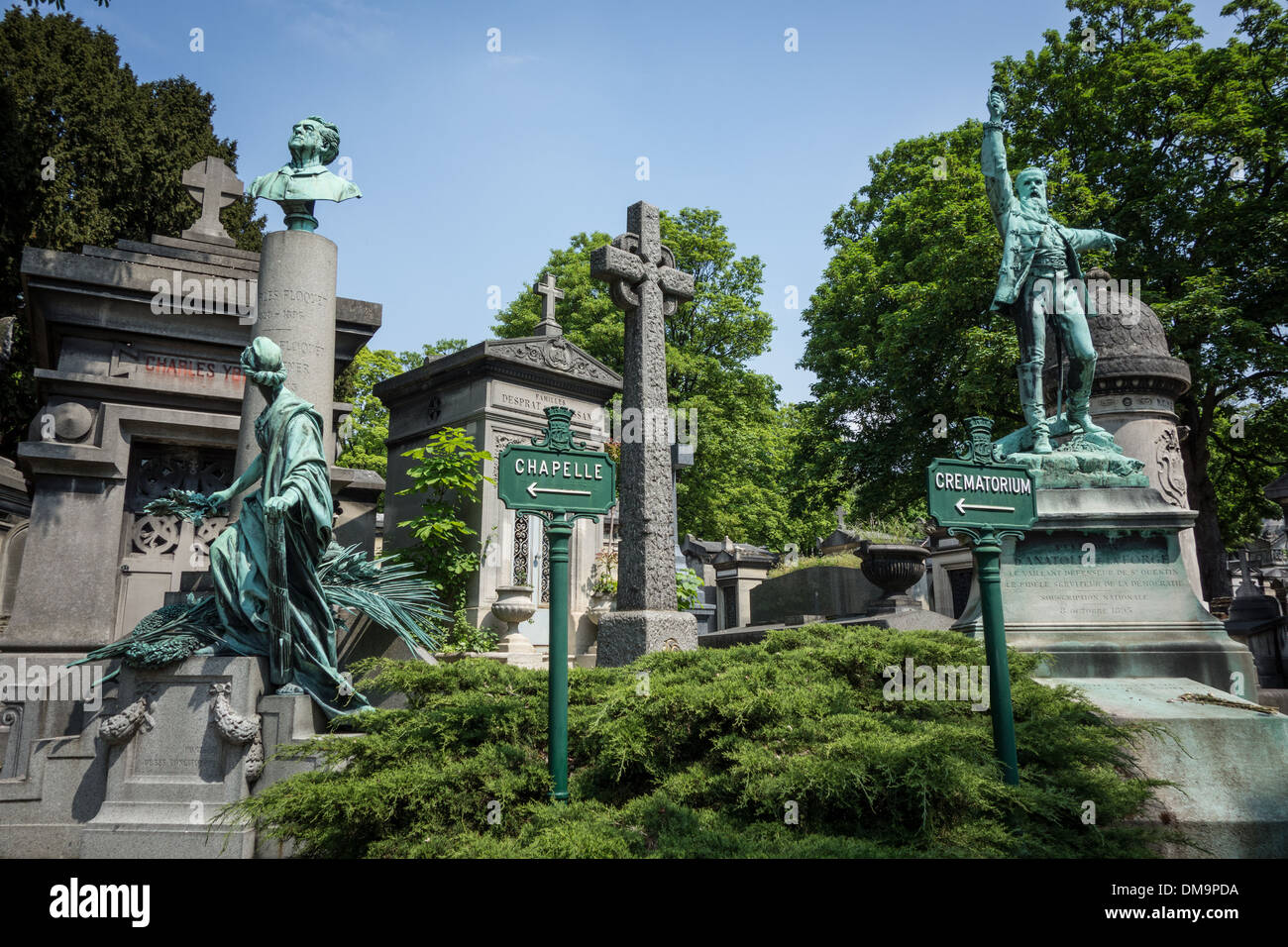 GRAVES AND BRONZES IN FRONT OF THE SIGNS FOR THE CHAPEL AND CREMATORIUM, PERE-LACHAISE CEMETERY, PARIS 20TH ARRONDISSEMENT, FRANCE Stock Photo