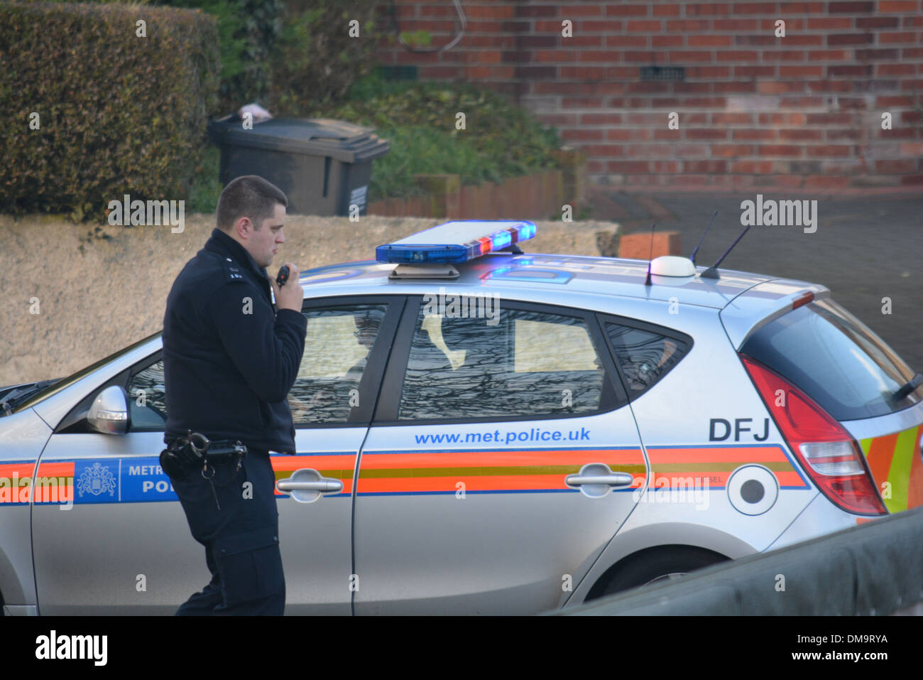 British police officer questioning suspect in vehicle and checking details. Stock Photo