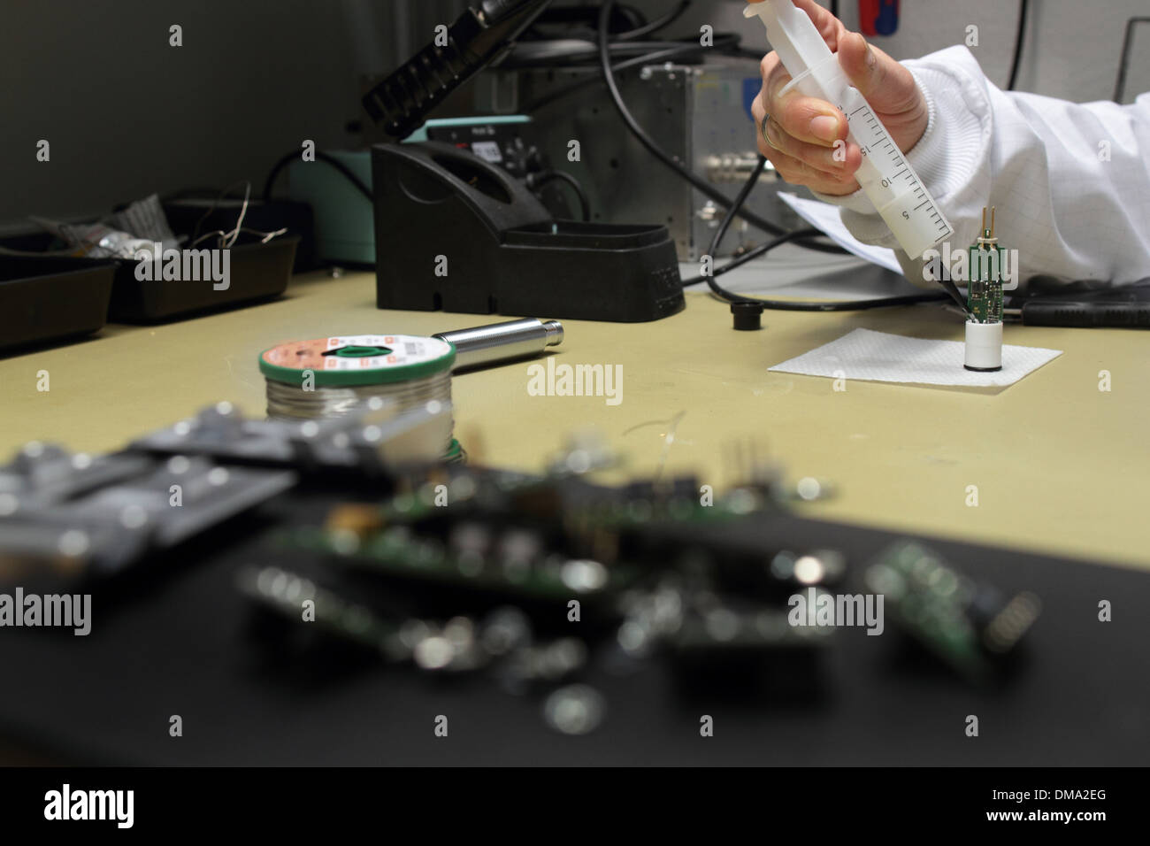 a person is cluing a microelectronics device Stock Photo