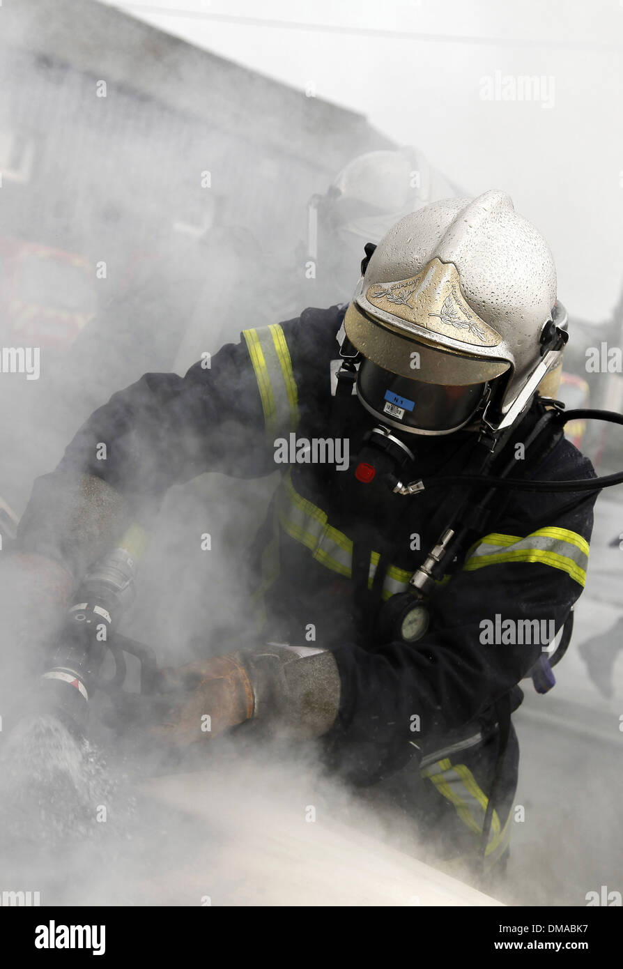 France, 2012: A firefighter fights a car fire Stock Photo