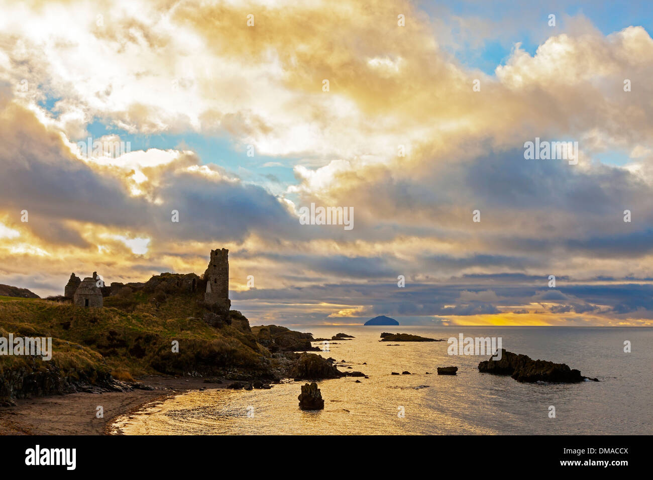 Dunure Castle at sunset overlooking the Firth of Clyde with the island ...