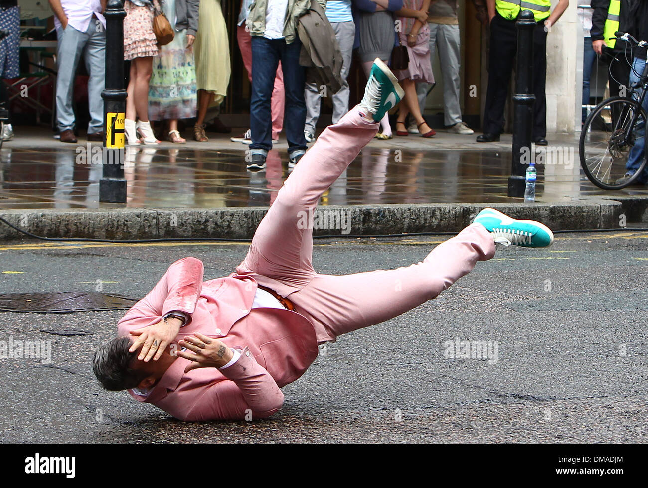 Robbie Williams performs a breakdance routine in a pink suit and turquoise  Nike high-top shoes as he films scenes for his new Stock Photo - Alamy