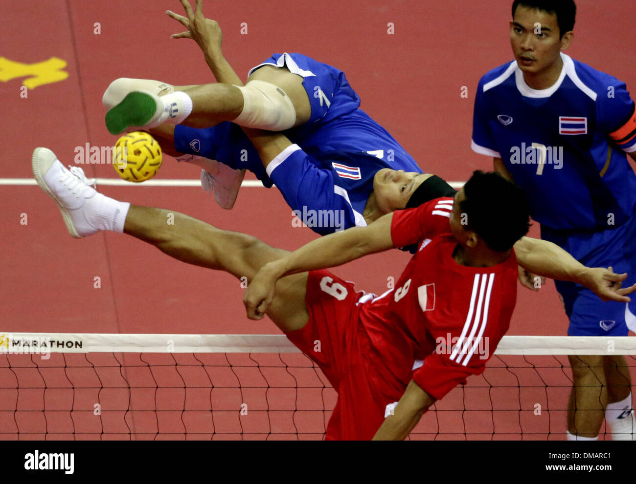Nay Pyi Taw, Myanmar. 13th Dec, 2013. A player of Indonesia (front) tries to block during the men's Sepak Takraw match between Thailand and Indonesia in the 27th Southeast Asian (SEA) Games in Nay Pyi Taw, Myanmar, Dec. 12, 2013. © U Aung/Xinhua/Alamy Live News Stock Photo