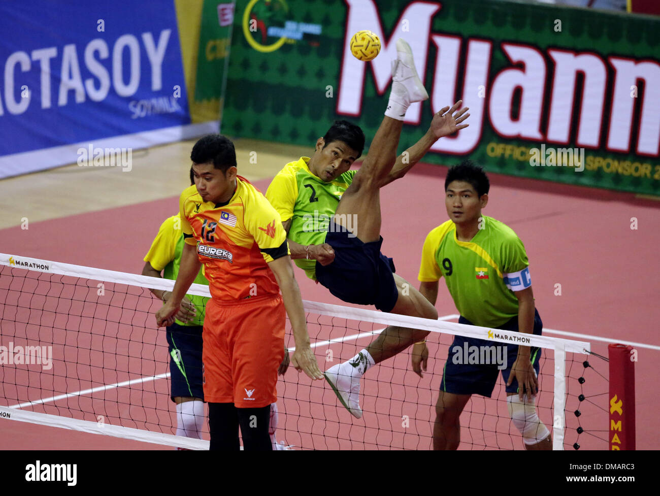 Nay Pyi Taw, Myanmar. 13th Dec, 2013. A player of Myanmar (2nd R) hits a shot during the men's Sepak Takraw match between Myanmar and Malaysia in the 27th Southeast Asian (SEA) Games in Nay Pyi Taw, Myanmar, Dec. 12, 2013. © U Aung/Xinhua/Alamy Live News Stock Photo