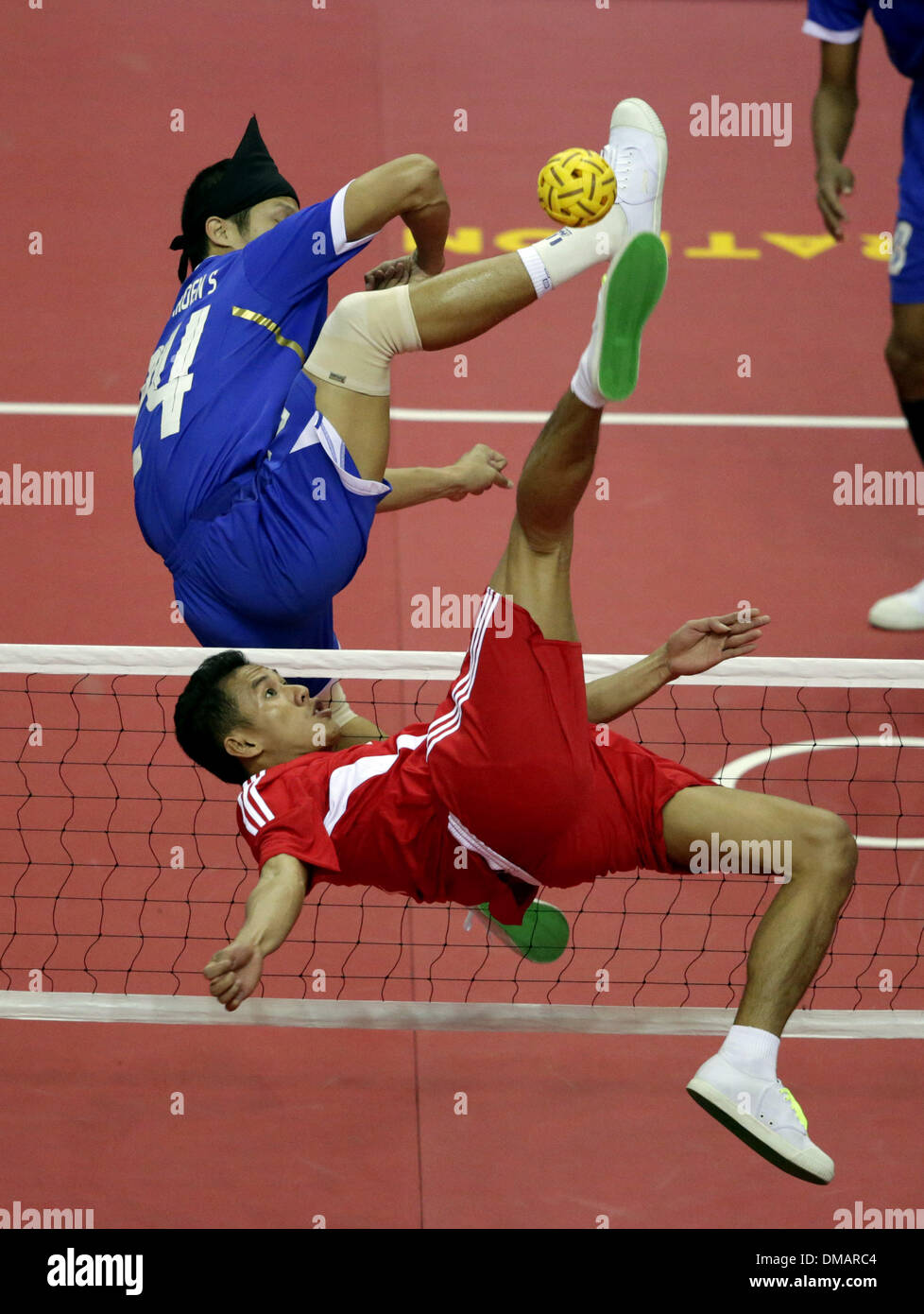 Nay Pyi Taw, Myanmar. 13th Dec, 2013. A player of Indonesia (front) hits a shot during the men's Sepak Takraw match between Thailand and Indonesia in the 27th Southeast Asian (SEA) Games in Nay Pyi Taw, Myanmar, Dec. 12, 2013. © U Aung/Xinhua/Alamy Live News Stock Photo