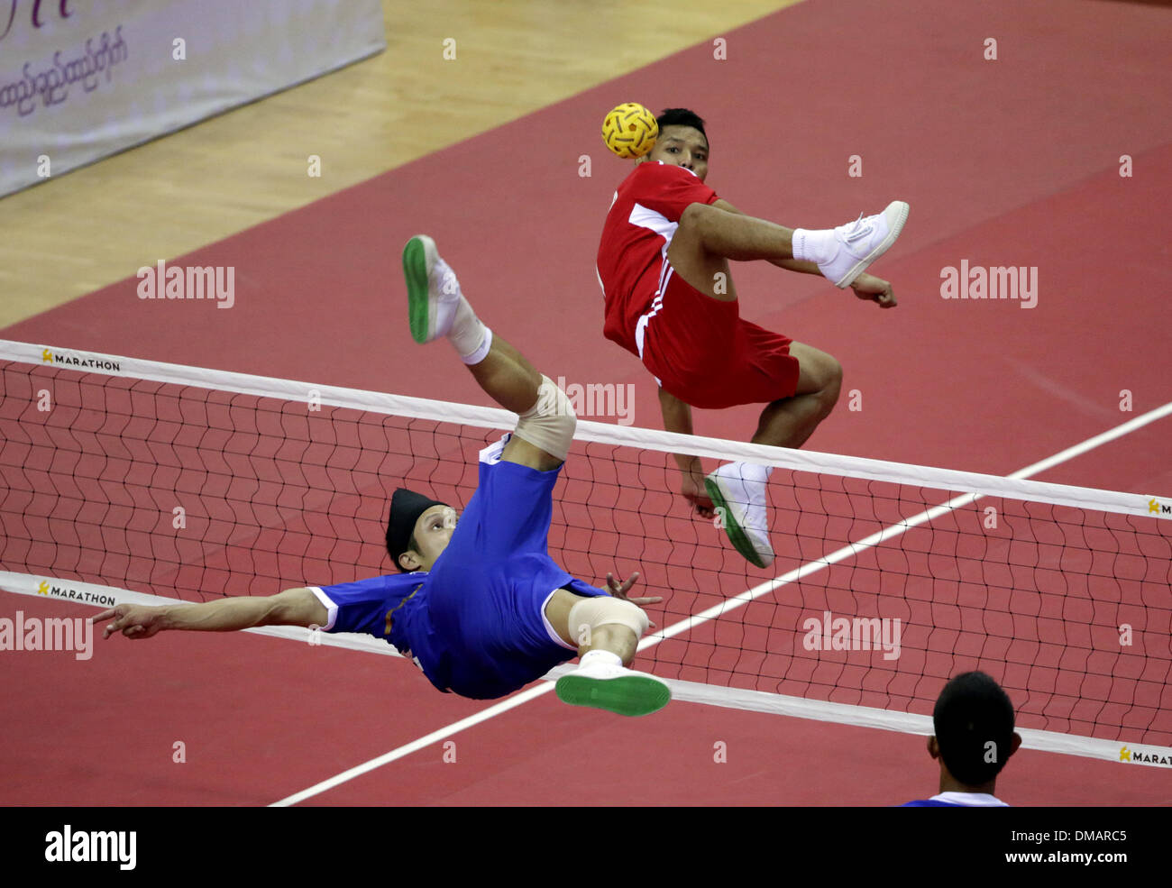 Nay Pyi Taw, Myanmar. 13th Dec, 2013. A player of Thailand (front) hits a shot during the men's Sepak Takraw match between Thailand and Indonesia in the 27th Southeast Asian (SEA) Games in Nay Pyi Taw, Myanmar, Dec. 12, 2013. © U Aung/Xinhua/Alamy Live News Stock Photo