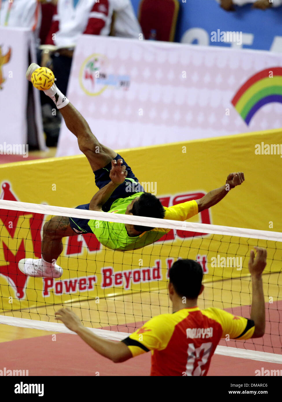 Nay Pyi Taw, Myanmar. 13th Dec, 2013. A player of Myanmar (rear) hits a shot during the men's Sepak Takraw match between Myanmar and Malaysia in the 27th Southeast Asian (SEA) Games in Nay Pyi Taw, Myanmar, Dec. 12, 2013. © U Aung/Xinhua/Alamy Live News Stock Photo