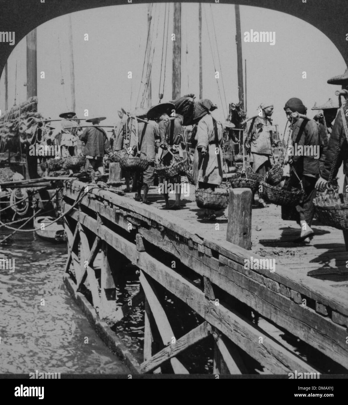 Coolies Carrying Filled Baskets on Docks, Hong Kong, 1910 Stock Photo