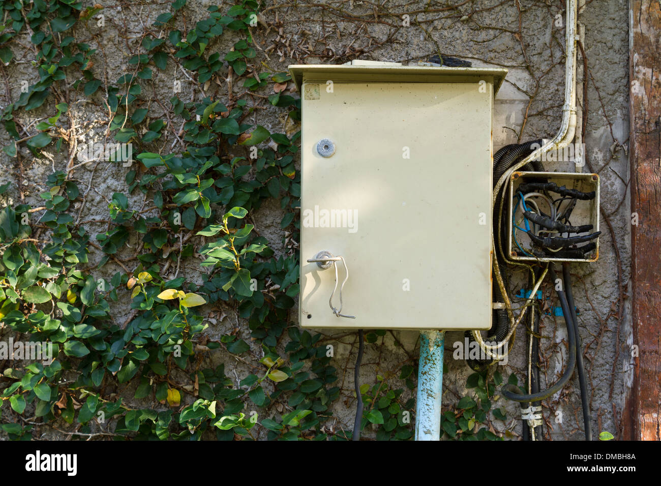 Unsafe Electrical control cabinets on concrete wall Stock Photo