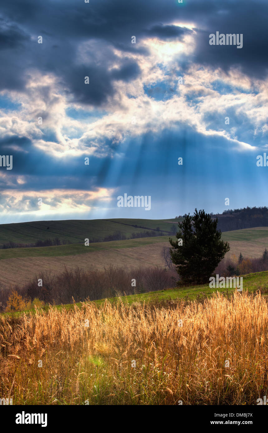 Sun rays coming out of clouds in beautiful mountain scenery Stock Photo