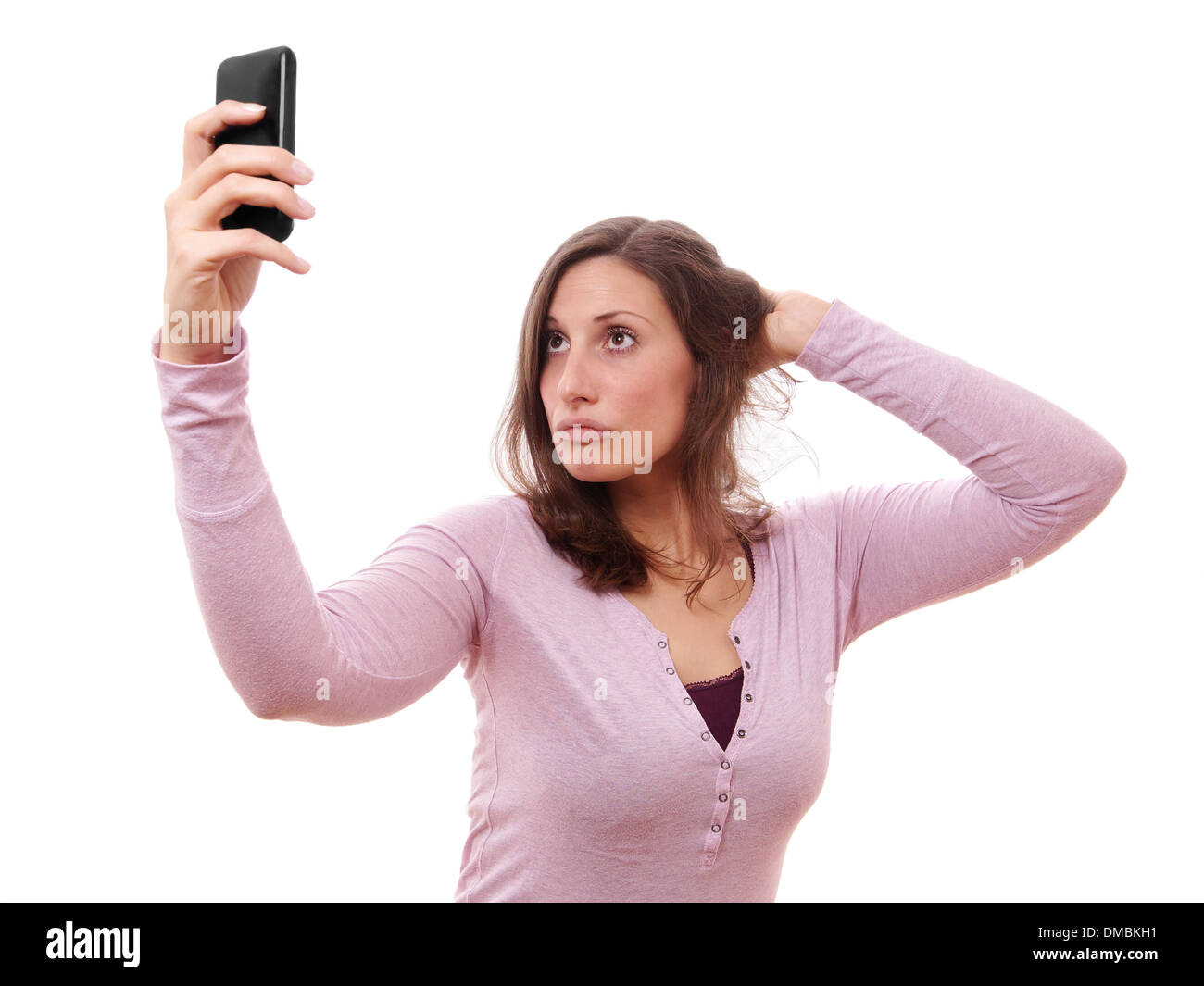 young woman making duckface while taking a selfportrait with her smartphone Stock Photo
