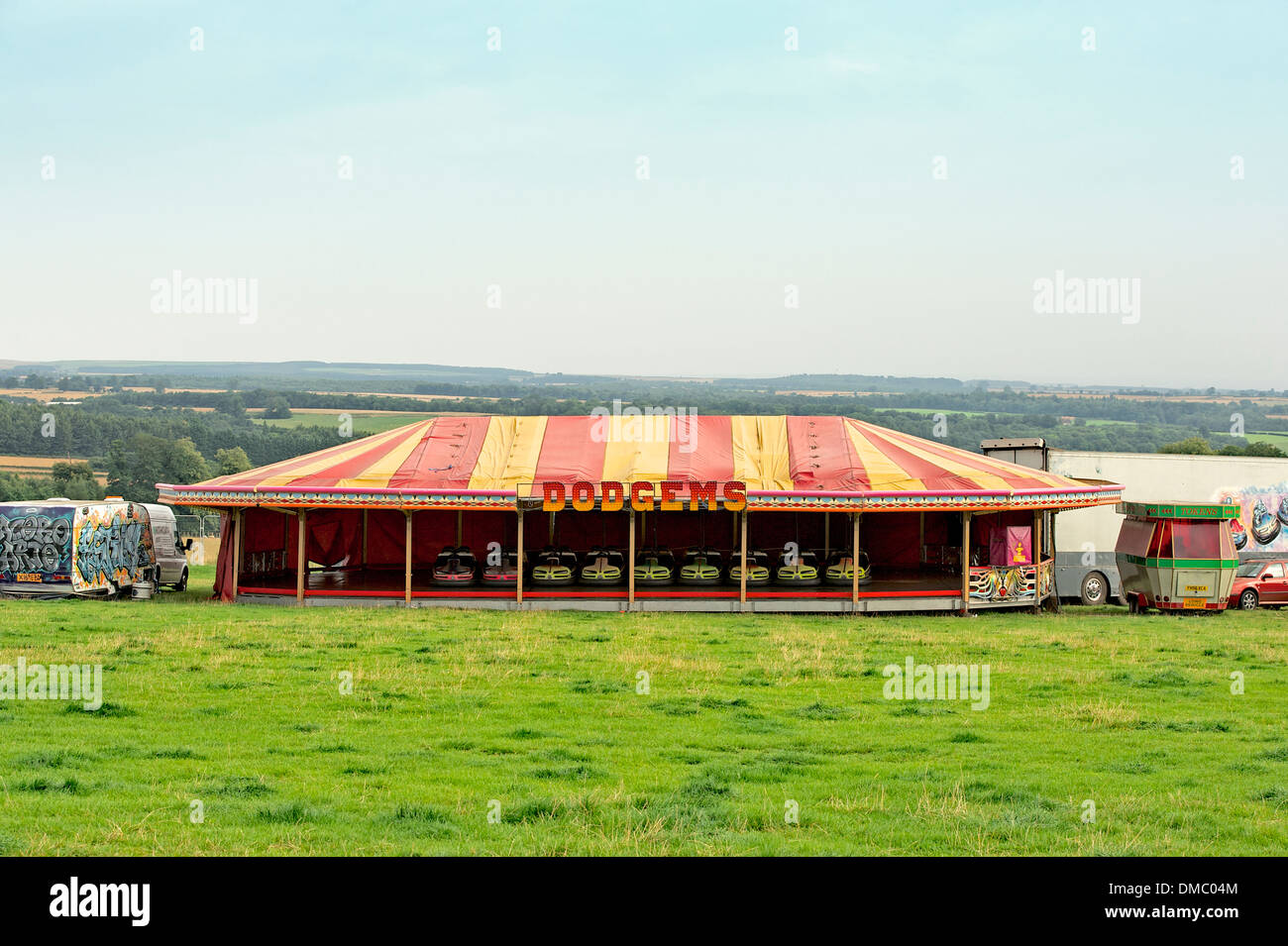 Parked dodgems in a red and yellow colorful colourful tent in a field at a British music festival. Stock Photo