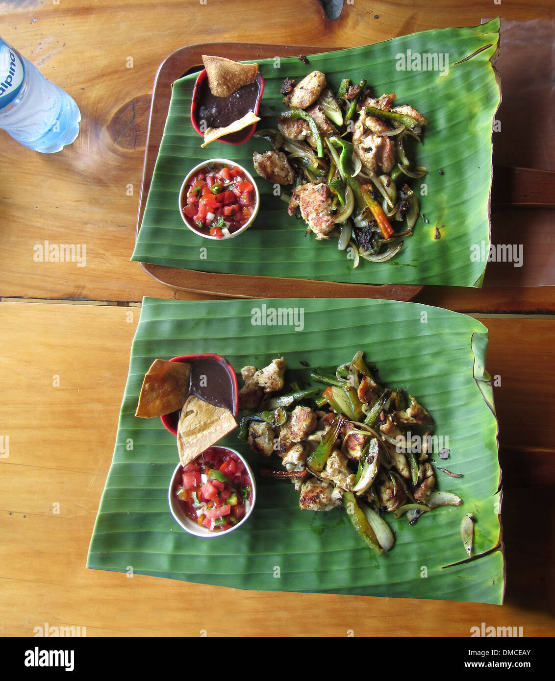 Typical Costa Rican lunch served at a small restaurant, sauteed meats and vegetables on a large fresh leaf. Stock Photo