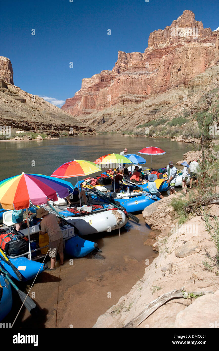 White water rafts with colorful umbrellas tied up alongside the