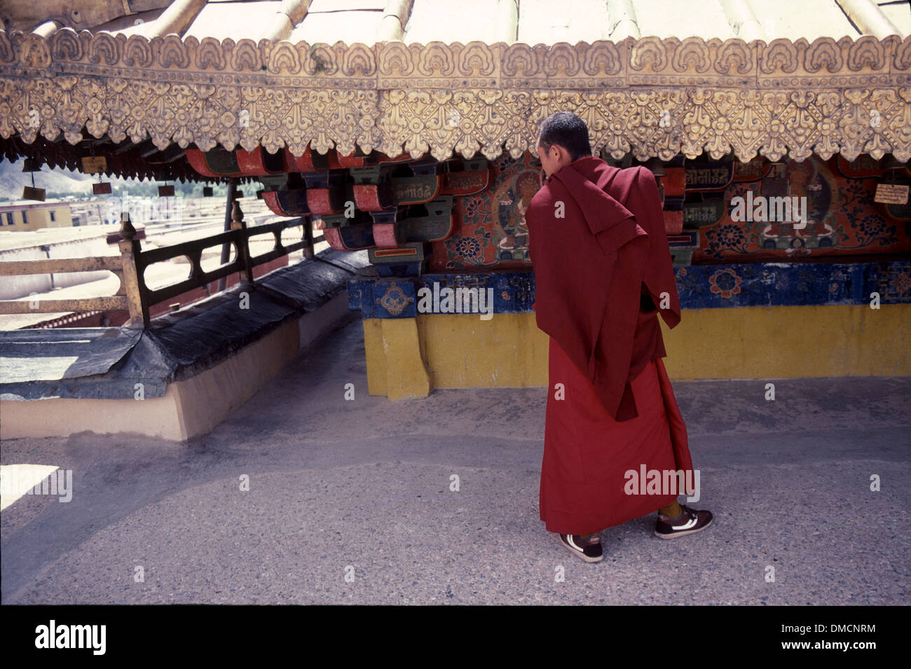 A lama walking on the rooftop of Jokhang Monastery, Lhasa, Tibet Stock Photo